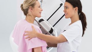 Uma mulher com uma infermeira pegutando se a mamografia doi