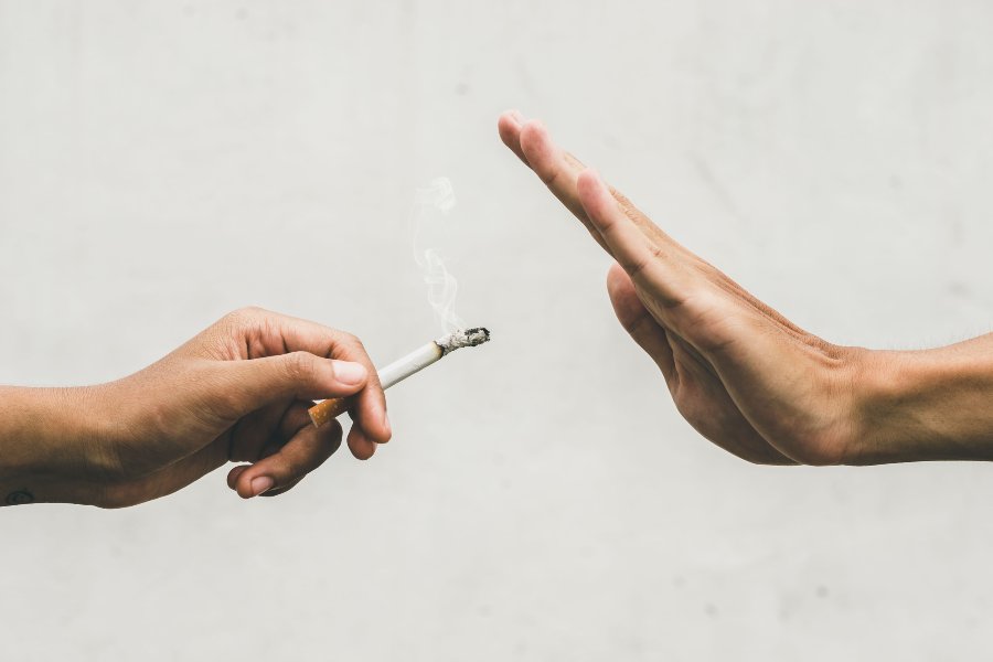 Mão oferecendo cigarro, e outra recusando.