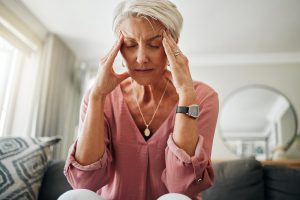 Mulher madura com as mãos na cabeça